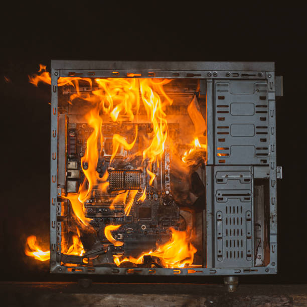 istock computer unit is burning with open fire and smoke from overheating, on a black isolated background 2032494114