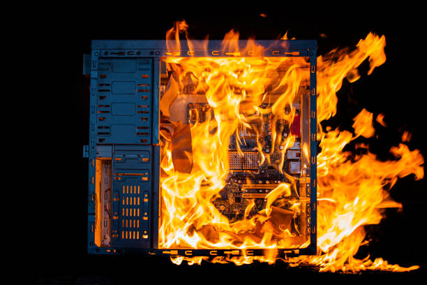 istock computer unit is burning with open fire and smoke from overheating, on a black isolated background 2032495192