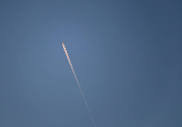 Airplane in the blue sky with white trace of the plane copy space