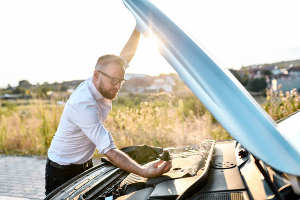 istock Bearded Businessman Removing Car Oil Lid To Check Engine While Car Stops Abruptly 2032522051