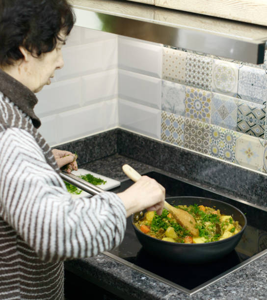 istock Elderly Woman Preparing Vegetable Stew 2032536024