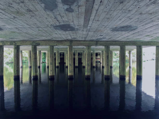 istock Under the bridge with reflection in the water of the river, perspective 2032544295