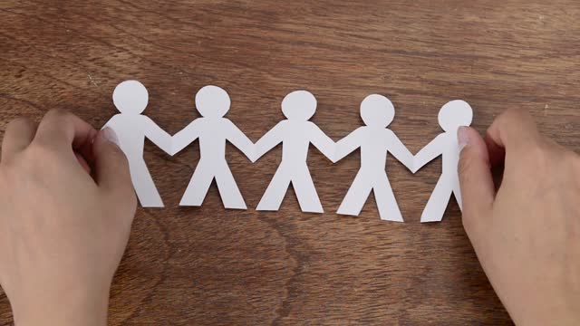 Cutting and folding a group of people on paper
