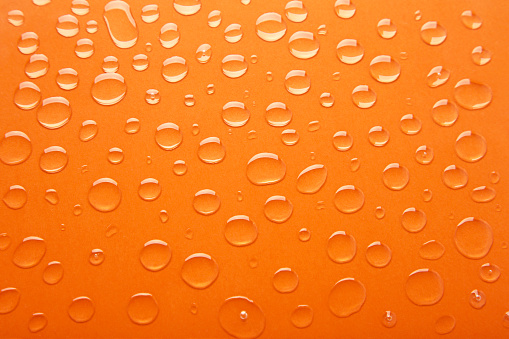 Water drops on orange background. Top view