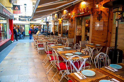 Alicante, Alicante - Spain - 01-07-2024: Outdoor dining at a lively street in Alicante, showcasing the city's charming cafe culture and bustling day-to-day life