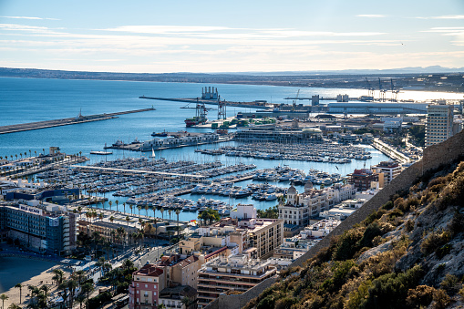 Alicante, Alicante - Spain - 01-07-2024: Breathtaking view of Alicante's port and coastline from Santa Barbara Castle under a brilliant sun