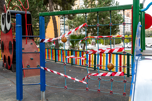 Cartagena, Murcia - Spain - 01-16-2024: A vibrant playground is cordoned off with red and white tape