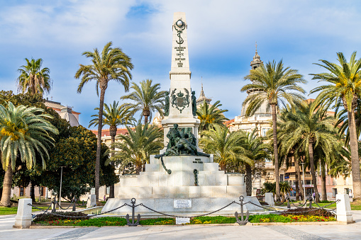 Cartagena, Murcia - Spain - 01-16-2024: Stately war memorial amidst lush palms, honoring history in Cartagena's vibrant cityscape