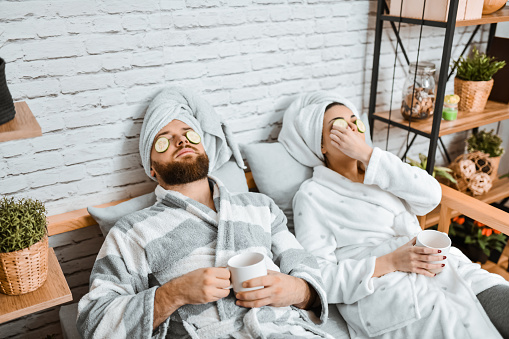 Couple Taking A Nap With Cucumber Slices On Eyes While Relaxing After Bath