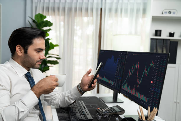 istock Trader analyzing holding coffee cup focusing on phone and stock screen. Surmise. 2032571898