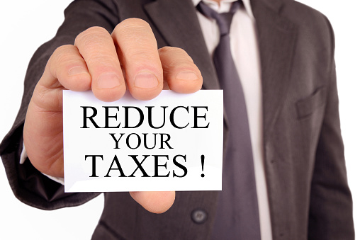 Anonymous man holding a card that says reduce your taxes