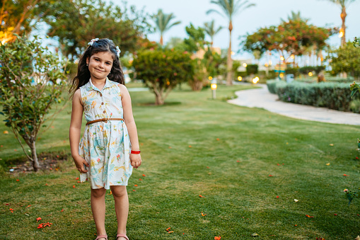 Portrait of a beautiful little girl in the garden in Hurghada, Egypt.