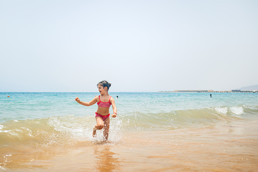Beautiful little girl playing on the beach in Hurghada in Egypt.