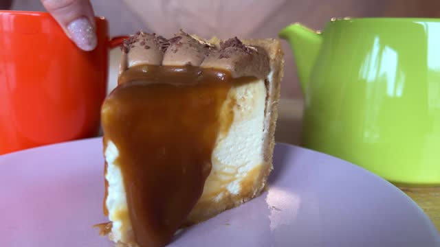 Delicious homemade cheesecake topped by caramel on a pink background.
