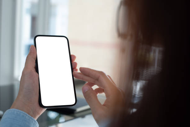 istock Cell phone blank screen mockup. Woman hand holding,  using mobile phone on desk at office.background empty space for advertise. Social media marketing, website template 2032580203