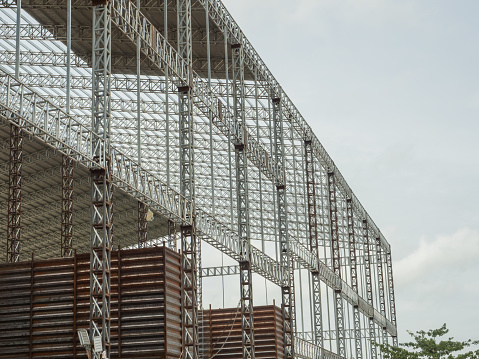 Factory is under construction, covering with welded structures of metal truss columns and roof beams.