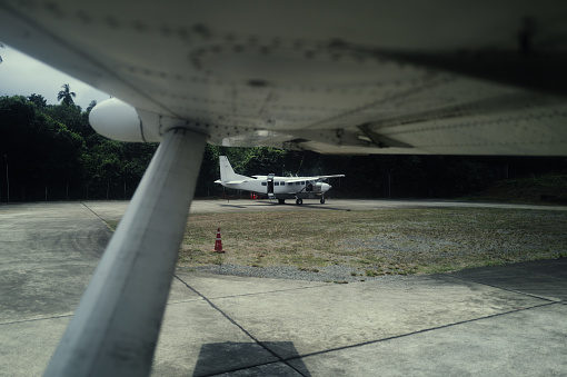 On a desolate island, a small aircraft sits parked on the beach, its turboprop engine gleaming in the sunlight. It stands as the sole connection, bridging this isolated island with the outside world, offering hope and possibilities for adventurers. Captured with the Leica Q3.