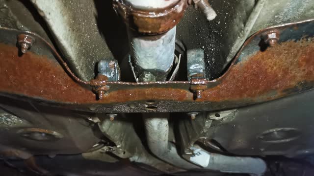 View of rusted exhaust pipe on lifted car
