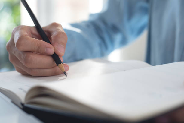 istock Female hand with pencil writing on paper notebook on table, close up. Woman taking note, planning business event on notepad, to do list reminder 2032627754