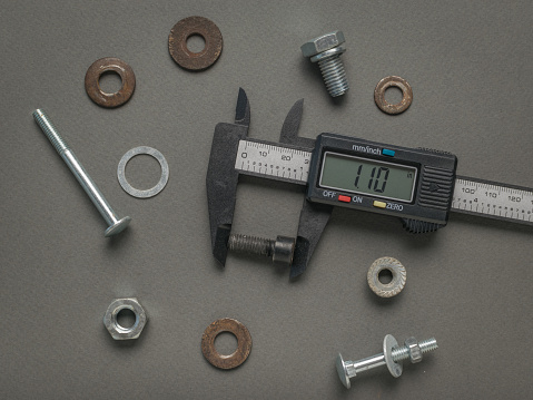 Measuring the dimensions of the screw with an electronic vernier caliper. A tool for accurate measurement of dimensions.