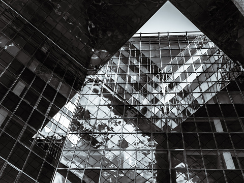Reflective glass facade of a building mirroring the sky