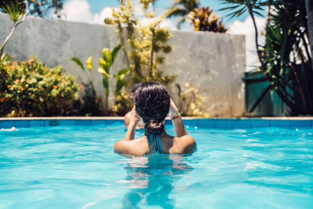 mulher nova que tira foto móvel na piscina no verão - mobilestock freedom enjoyment blue - fotografias e filmes do acervo