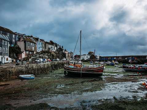 A sailboat is moored at a pier, ready for its next journey, Mevagissey, UK