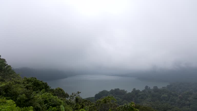 Timelapse of the fog on the Tamblingan Lake encompassed by dense forest, Bali, Indonesia