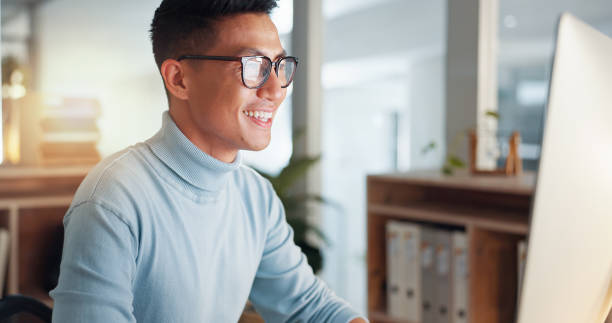 istock Asian man at computer, glasses and ideas, thinking and reading email, web review or article at digital agency. Research, reflection and businessman at tech startup networking on business website. 2032671649