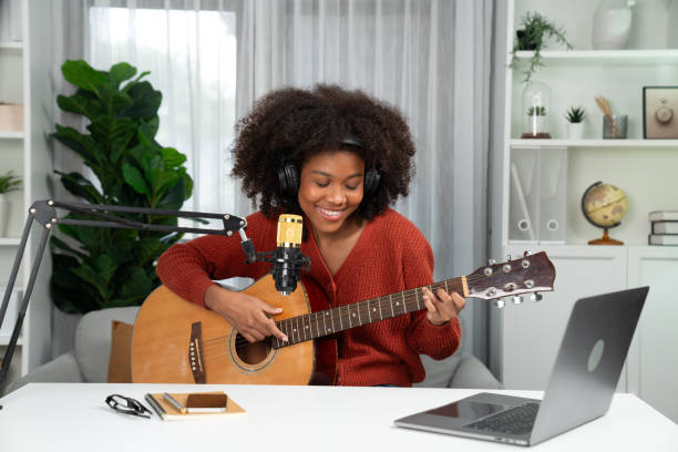 istock American African broadcasting on laptop with playing guitar. Tastemaker. 2032678605