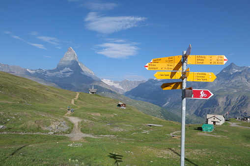 Direction signs and the Matterhorn under the blue sky in Zermatt.