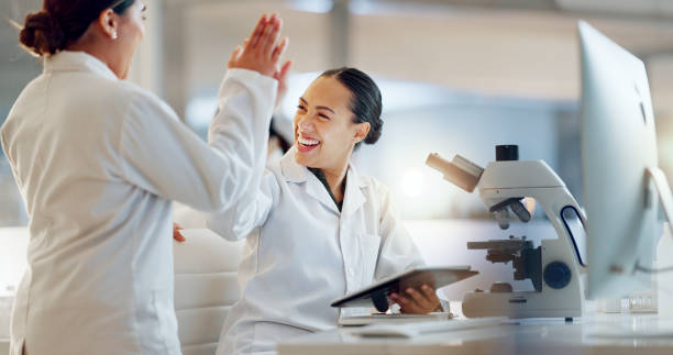 istock Teamwork, scientist or doctors high five for success, medicine breakthrough or partnership in lab. Science, collaboration or happy women celebrate medical support, goal target or DNA news with smile 2032712498