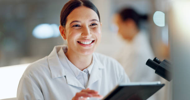 istock Scientist, woman and tablet, microscope or laboratory research for DNA analysis and happy with medical study. Student or science expert in biotechnology with digital software and lens check for data 2032712513