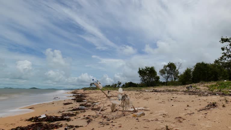 A timelapse of rubbish and ocean plastic washed up on a remote beach in northern Australia. The clouds race overhead, and the focus is a wooden structure with plastic and rubbish attached. In 4K.