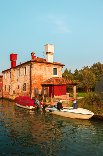 Venice, Veneto, Italy - 10/10/2020: Some people on a boat in the canal of Torcello, one of the islands near Venice