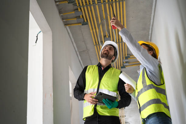 istock Hispanic latin engineer man and woman working with tablet computer and paper work in building at construction site 2032780395