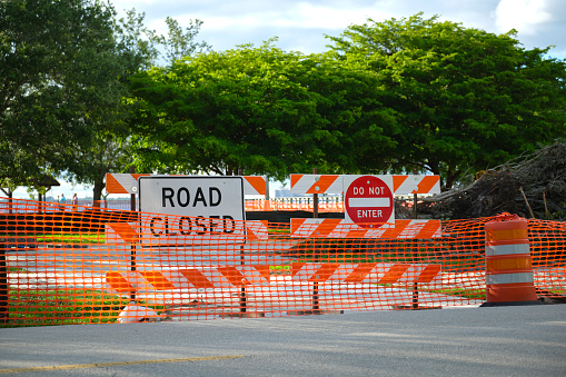 Road closed at construction site with protective fence barrier.
