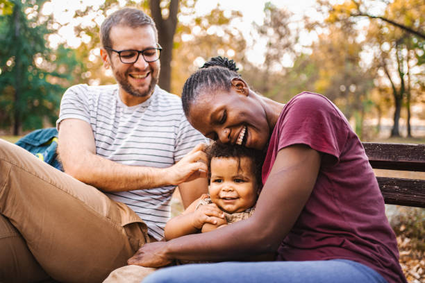 istock Mixed race couple is sitting on a park bench with their son 2032788927