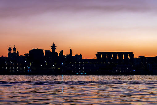 Silhouette of Luxor temple, view of the Nile river East bank at sunrise in Luxor, Egypt