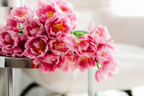 A bouquet of pink peonies on the table.​