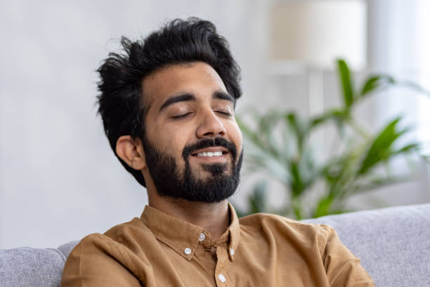 istock Relaxed young indian man enjoying a serene moment on a comfortable sofa at home 2032819983