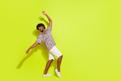 Full size photo of handsome young guy discotheque dancing clubber wear trendy leopard print outfit isolated on yellow color background.