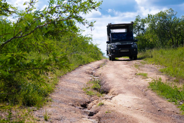 A photo of an abandoned Vehicle with visible damage located in the grassy plains of Kafue National Park, Zambia, hinting at a rugged adventure gone awry.
