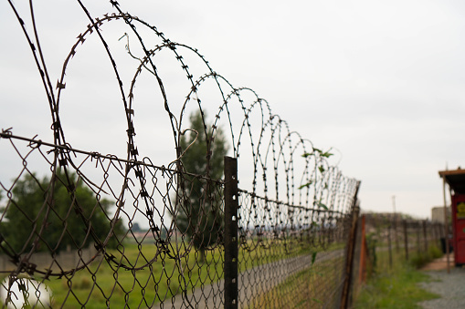 A photo of a fence featuring barbed wire, emphasizing the installation of security measures.