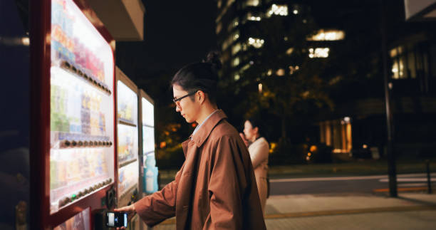 istock Vending machine, man and phone payment at night, automatic digital purchase or choice in city outdoor. Smartphone, shopping dispenser and Japanese business person on mobile technology in urban Tokyo 2032861441