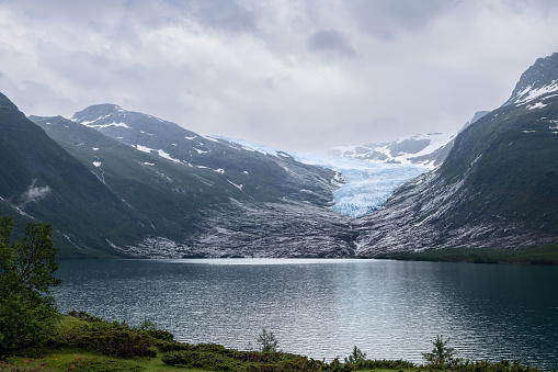 Overlooking Svartisen Glacier, this view captures the striking interplay between the ice, mountain slopes, and the calm reflective lake in Norway