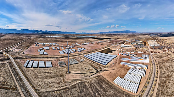 Drone view of a windmill manufacturing facility for large wind turbines, with mountain views