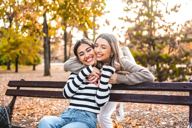 Two bestfriends having fun in the park in autumn