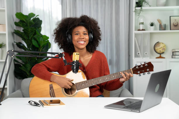 istock American African broadcasting on laptop with playing guitar. Tastemaker. 2032925694