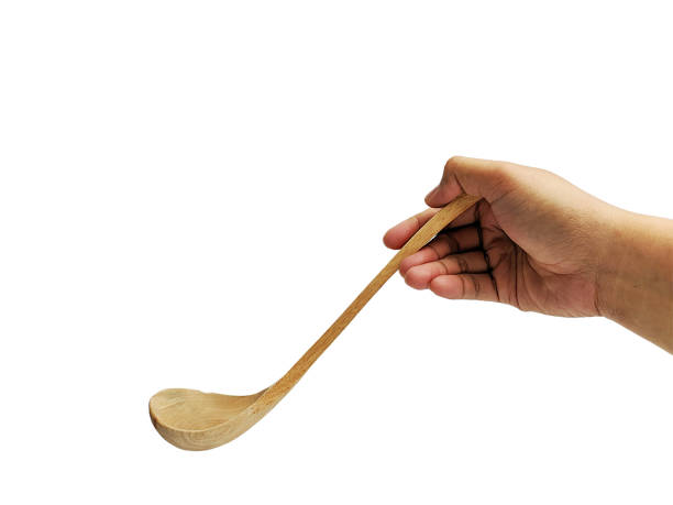 istock Hand holding Wooden soup spoon isolated on white background 2032944404